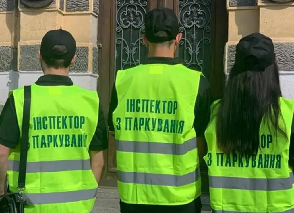 Троє інспекторів з паркування у світловідбивних жилетах