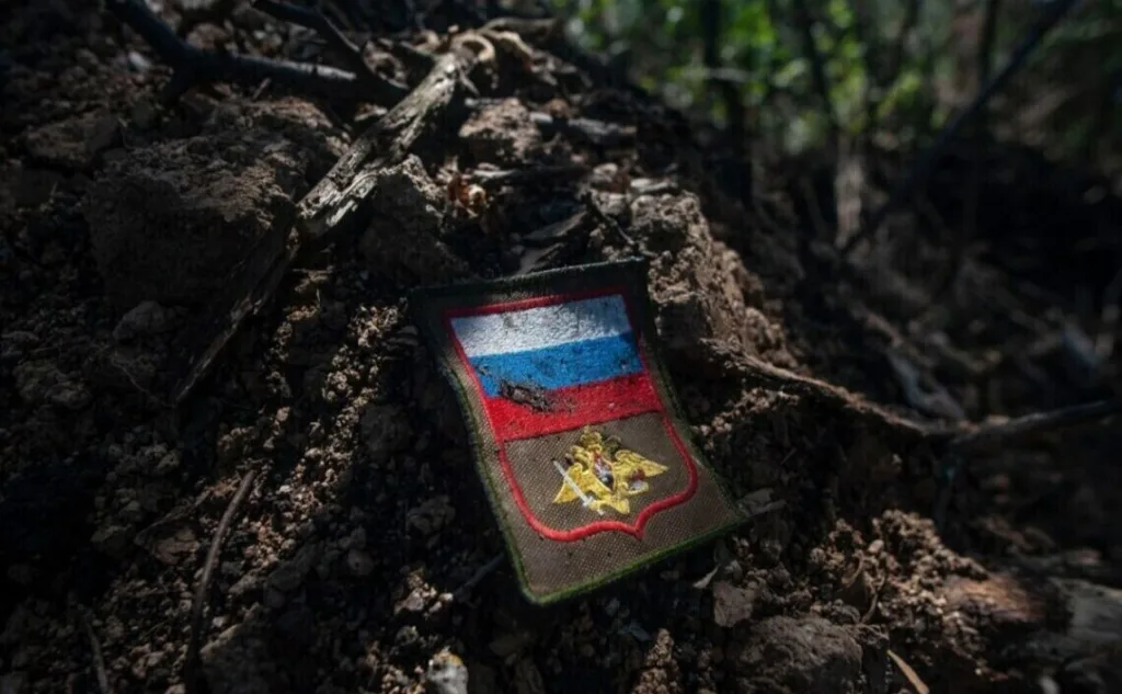 Російський військовий шеврон у ґрунті лісу