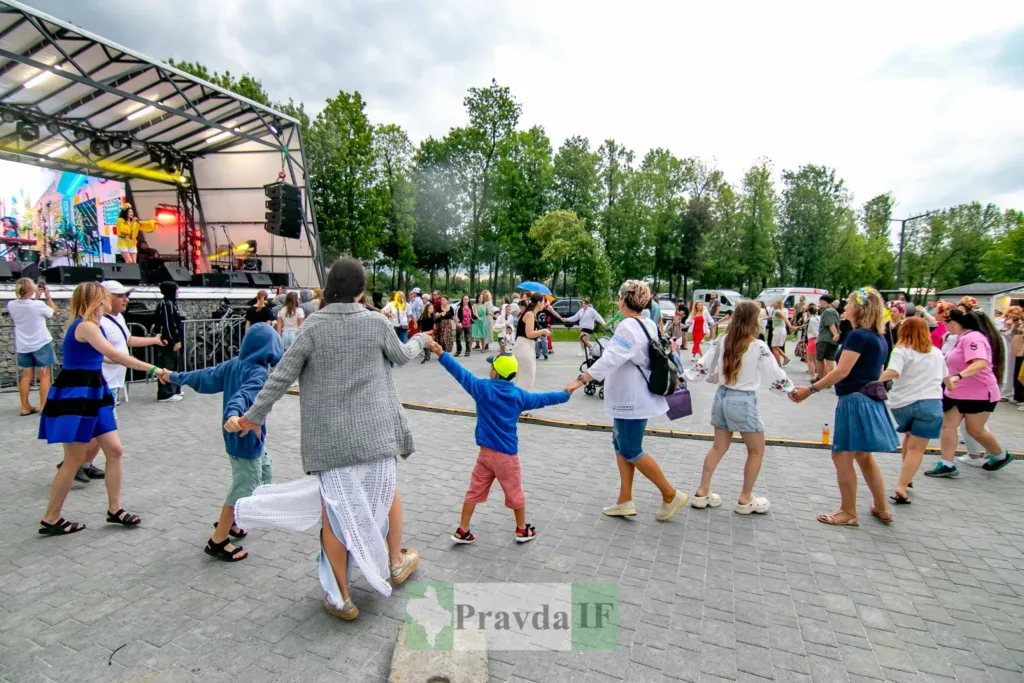 Люди танцюють у колі на вуличному концерті