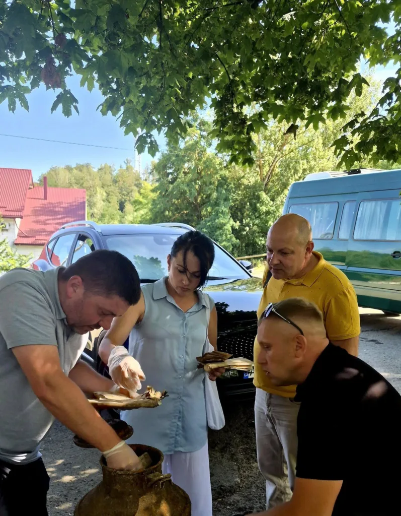 Люди оглядають знайдені предмети біля автомобілів
