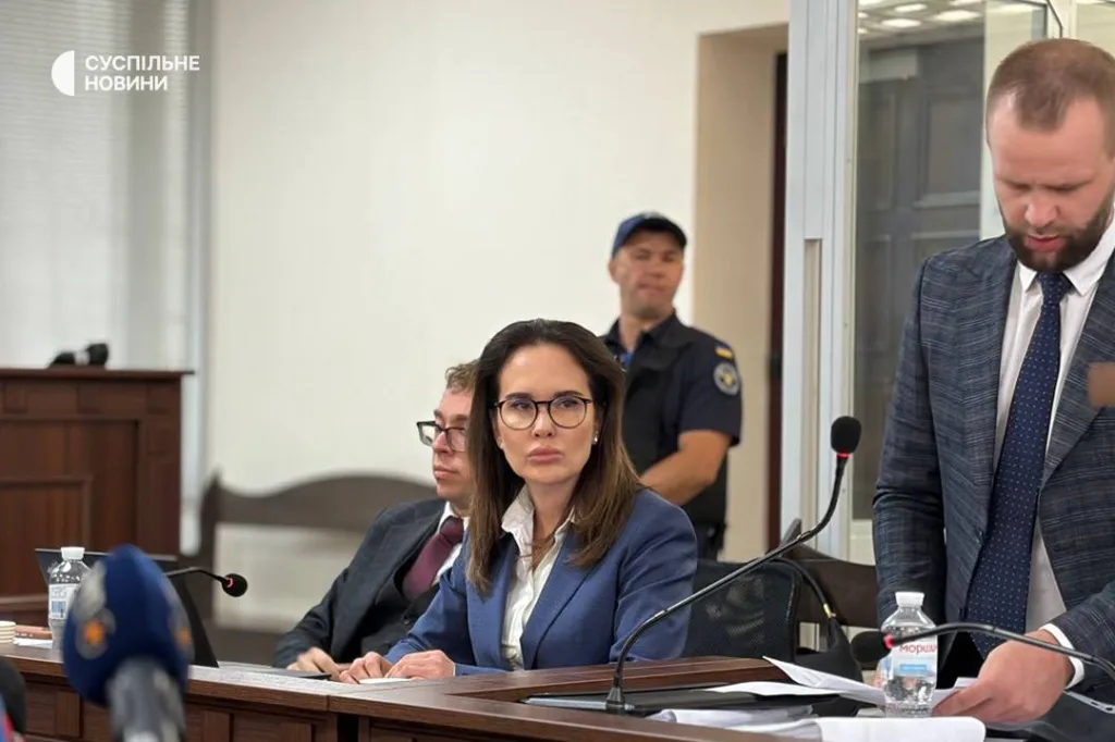 Жінка в синьому костюмі на судовому засіданні