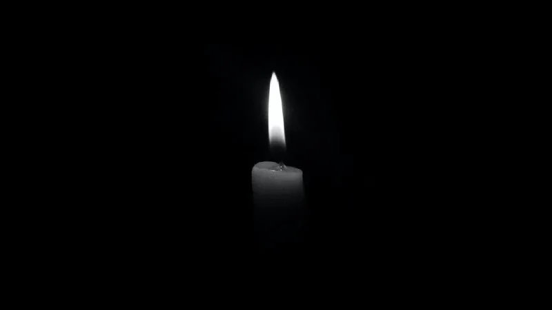 Запалена свічка світить у темряві