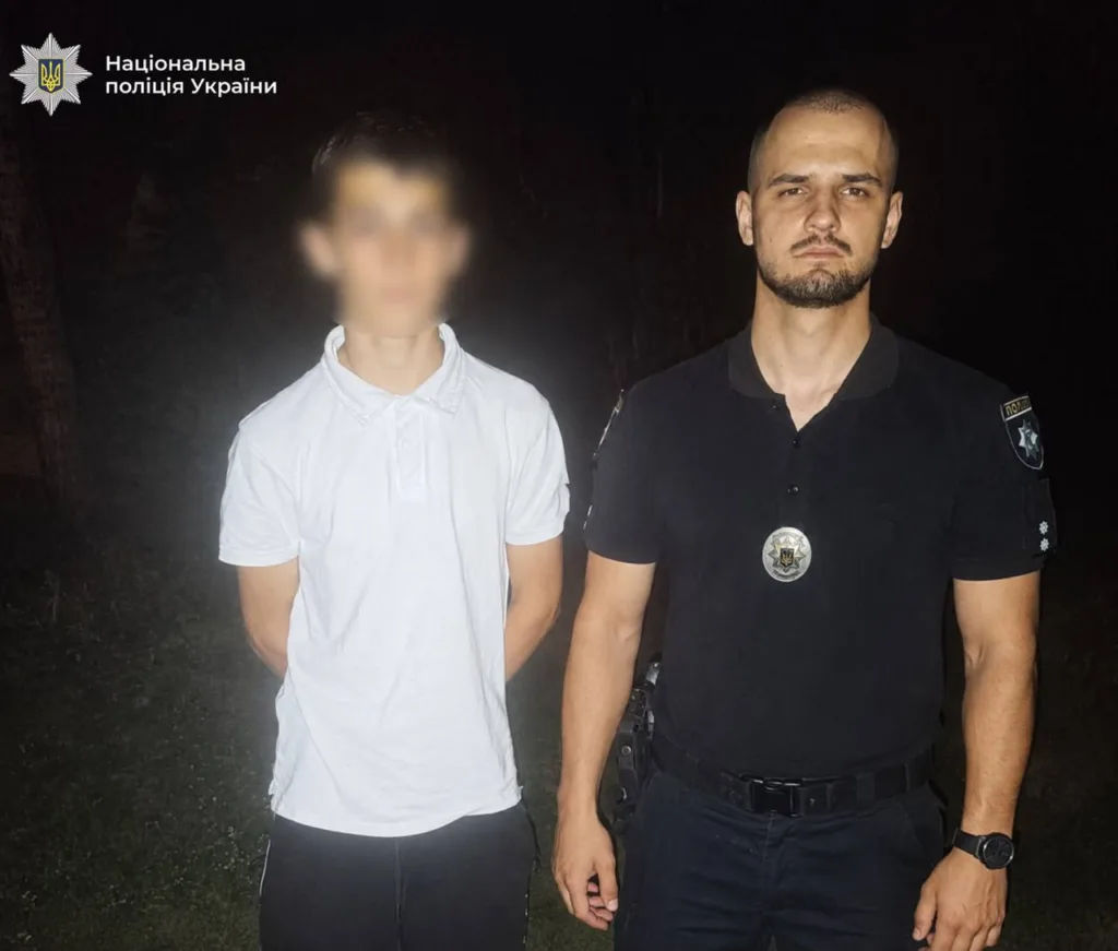 Поліцейський поруч із затриманим чоловіком уночі