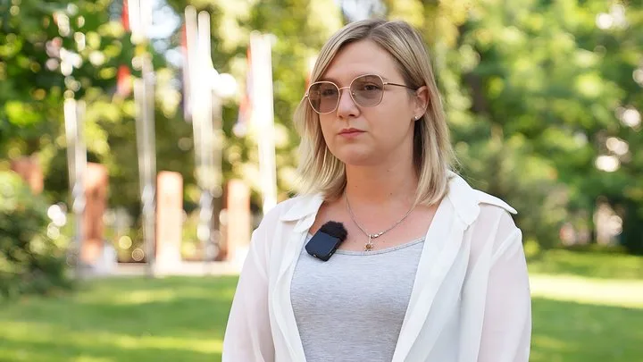 Жінка в окулярах із мікрофоном у парку