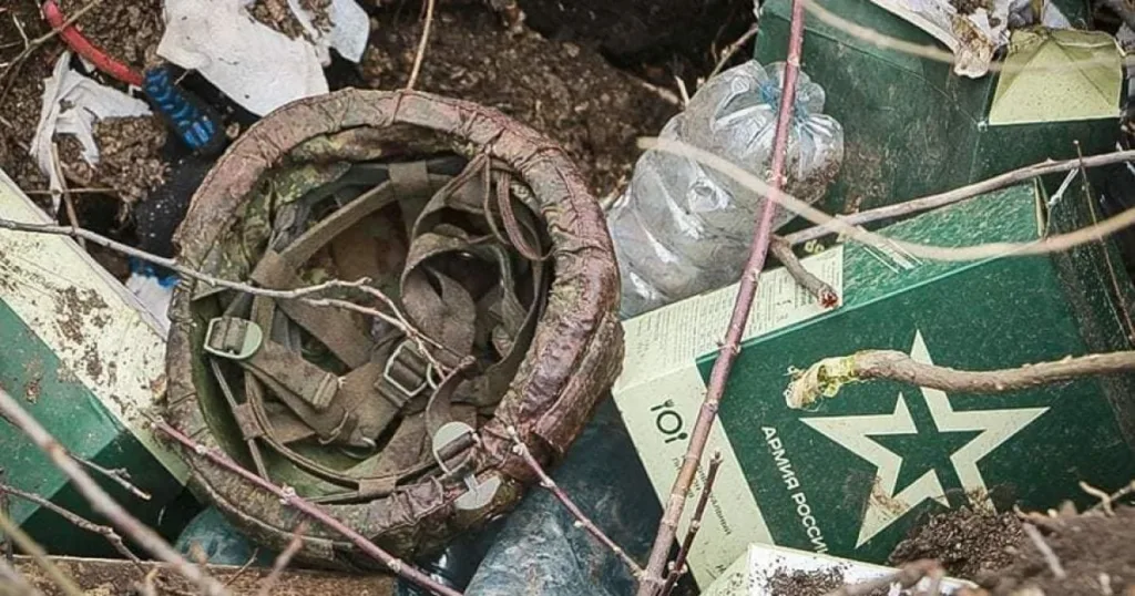 Пошкоджений російський шолом серед військового спорядження