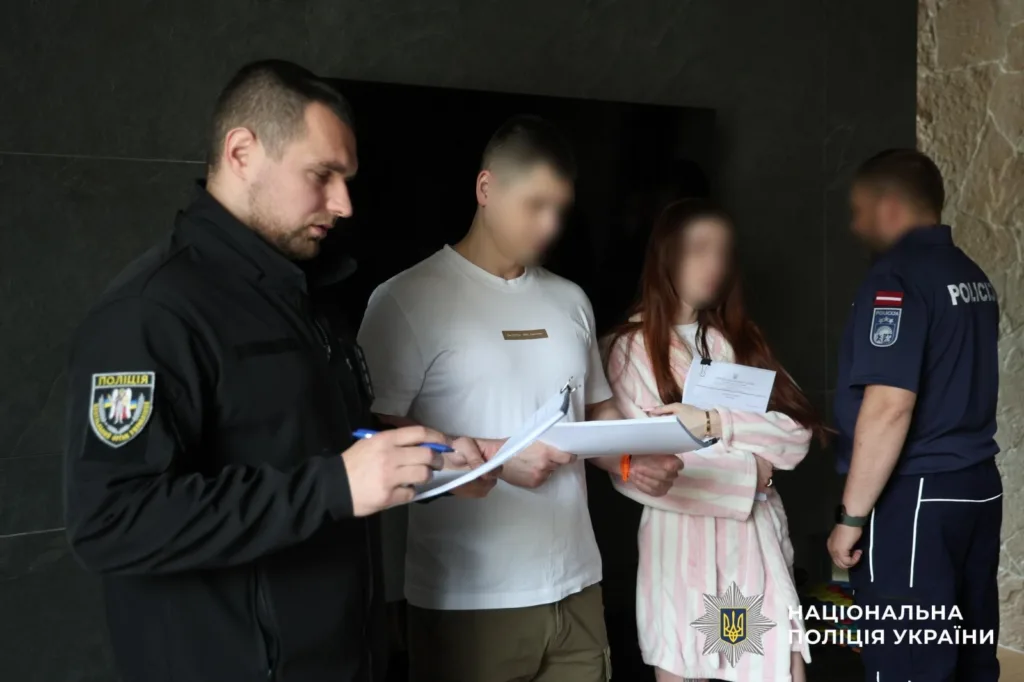 Поліцейські вручають документи двом людям із розмитими обличчями