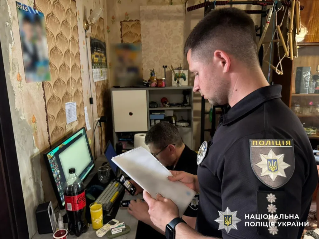 Поліцейські оглядають документи біля комп’ютера в кімнаті