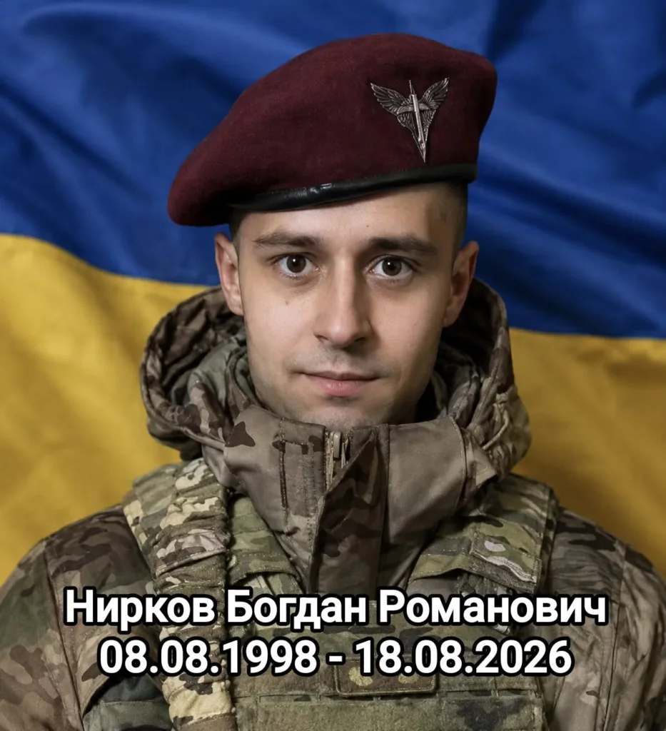 Портрет українського військового на тлі державного прапора
