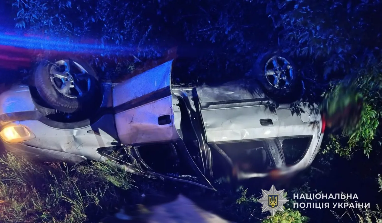 Перекинутий автомобіль у кюветі вночі