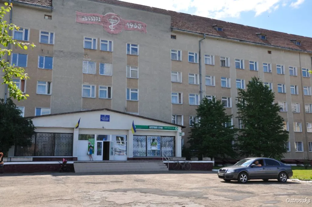 Фасад лікарні з аптекою та автомобілем