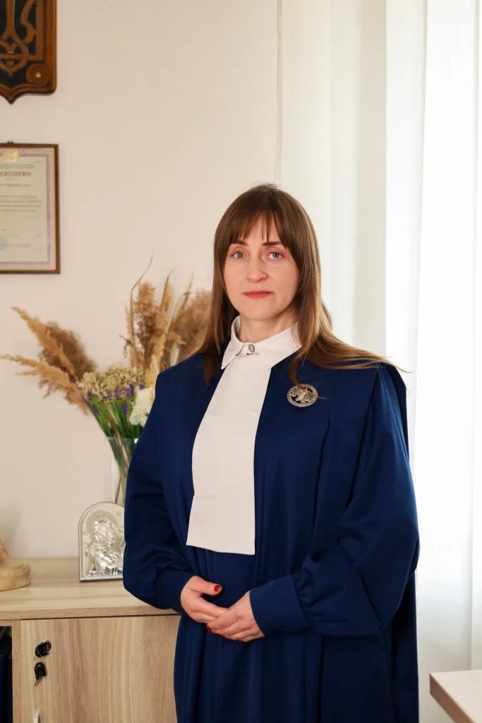 Жінка в синьому діловому костюмі в офісі