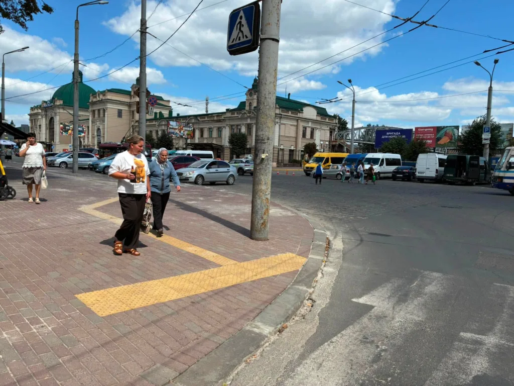 Пішоходи біля жвавої вулиці та історичної будівлі вокзалу