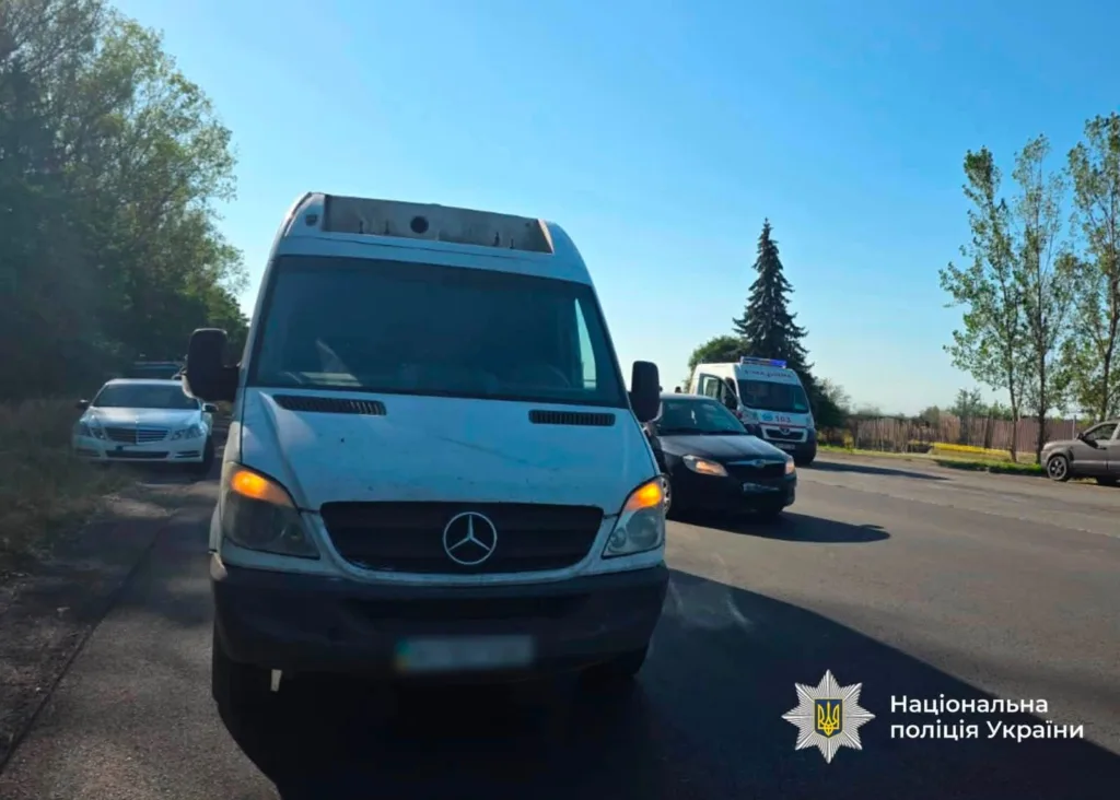 Мікроавтобус Mercedes на дорозі, поруч поліцейський автомобіль