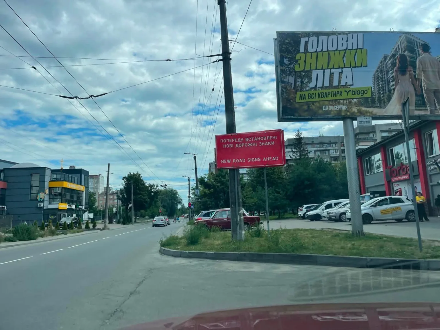 Міська вулиця з білбордом і попередженням про нові знаки