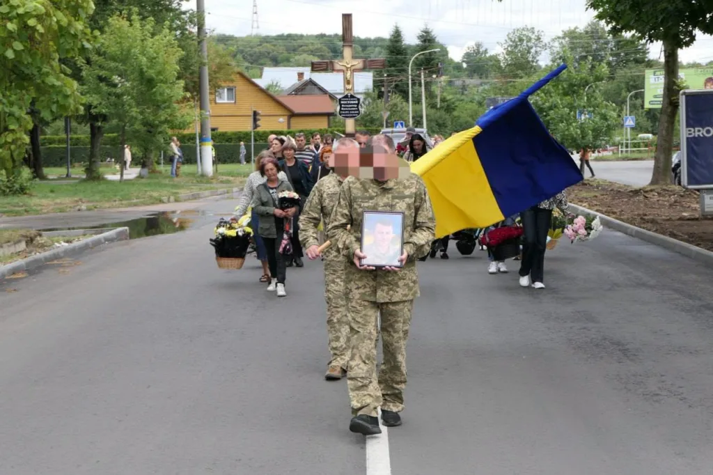 Похоронна процесія з українським прапором і портретом військового
