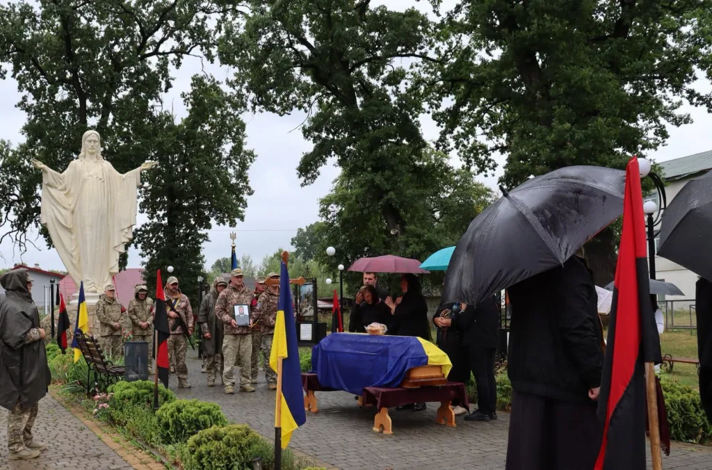 Похорон військового під дощем біля статуї Христа