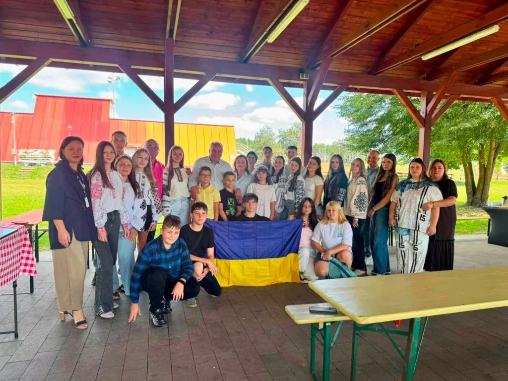 Група людей із українським прапором під альтанкою
