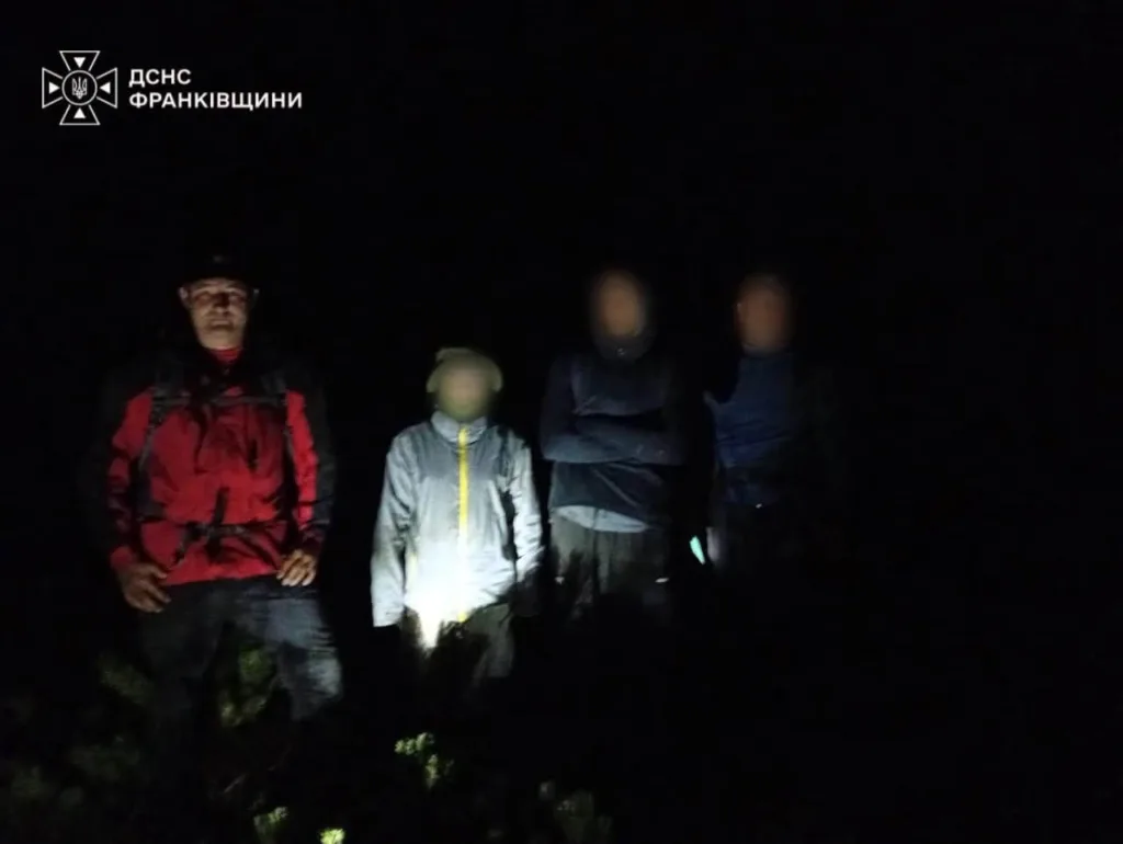 Рятувальник і троє людей уночі в лісі