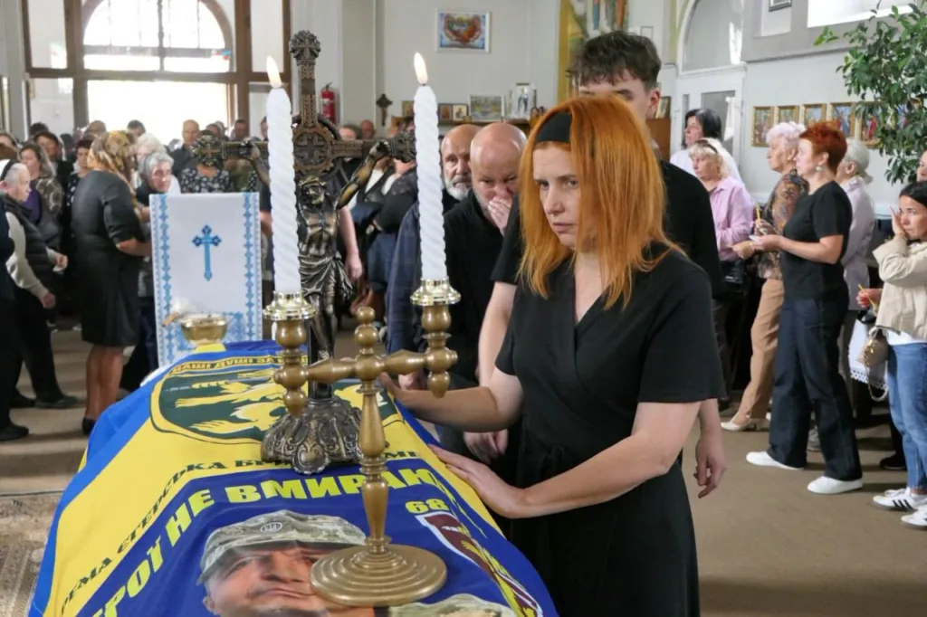 Жінка біля труни військового в храмі