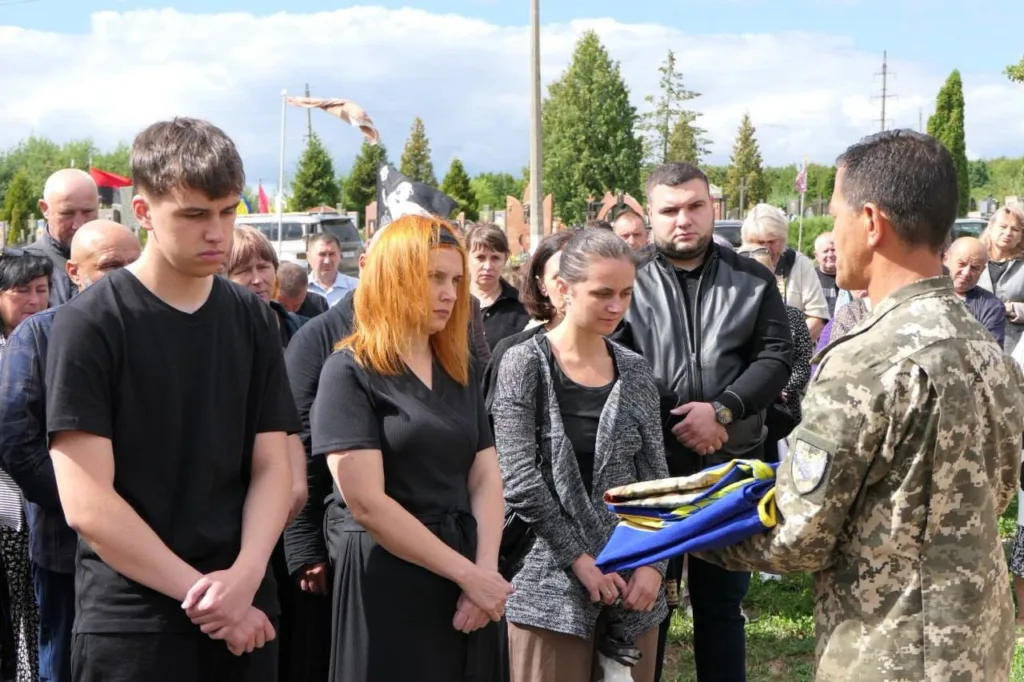 Військовий передає родині складений український прапор