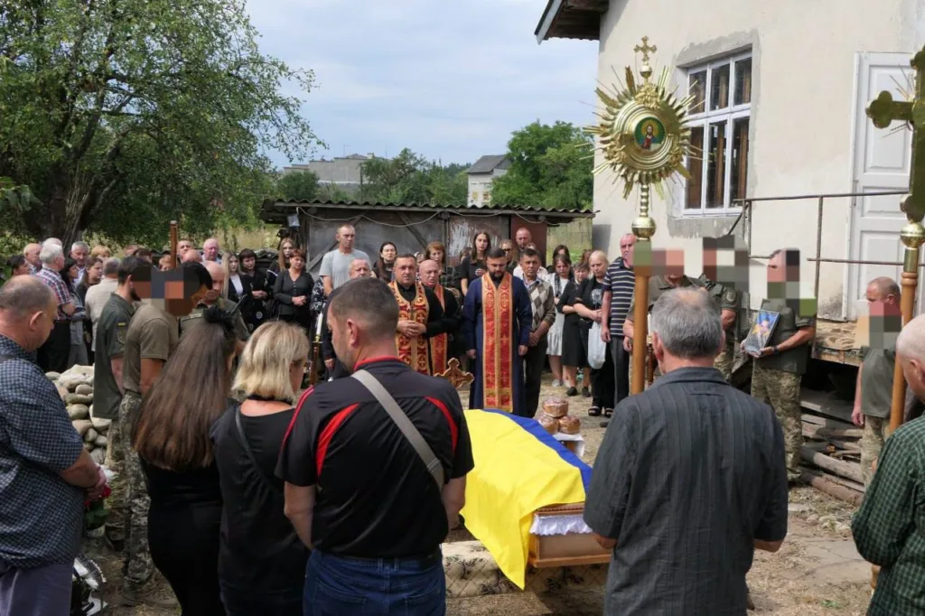 Похорон військового з труною, вкритою українським прапором