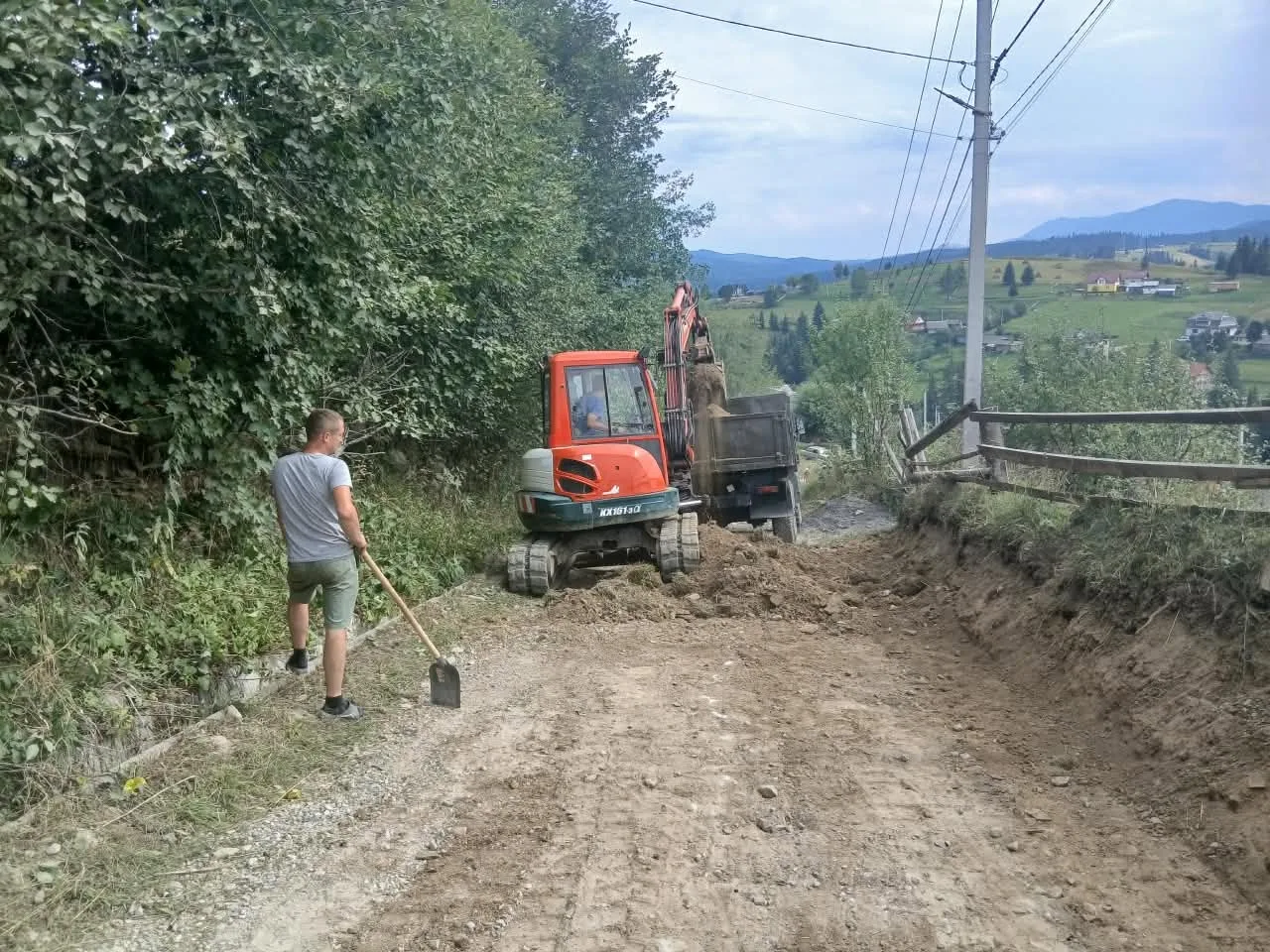 Екскаватор ремонтує ґрунтову дорогу в гірському селі