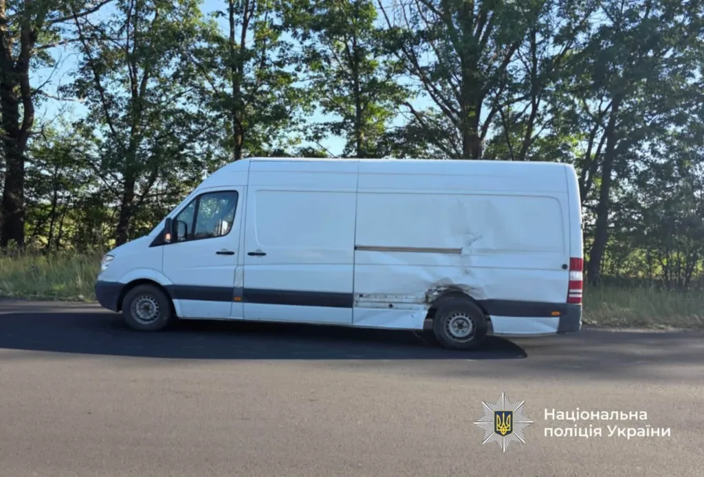 Білий фургон із пошкодженим боком на дорозі
