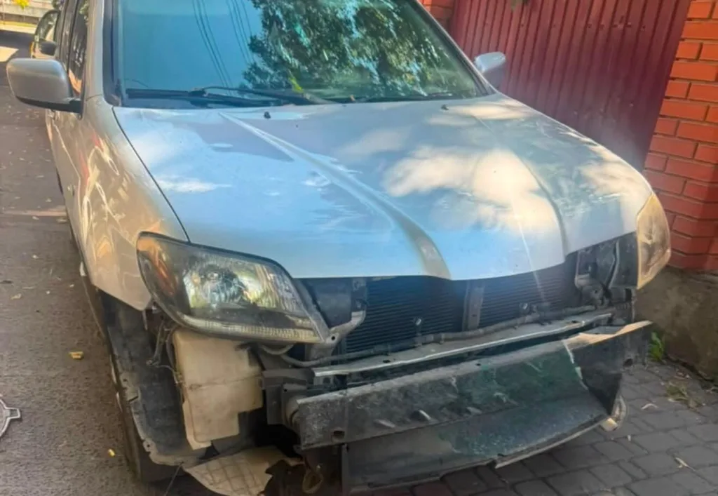Сріблястий автомобіль із пошкодженим переднім бампером