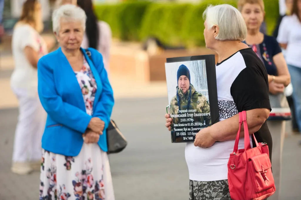 Жінка тримає портрет загиблого українського військового