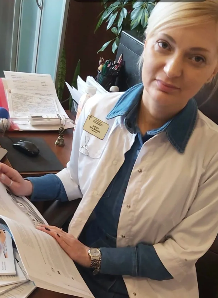 Медична працівниця в білому халаті за робочим столом