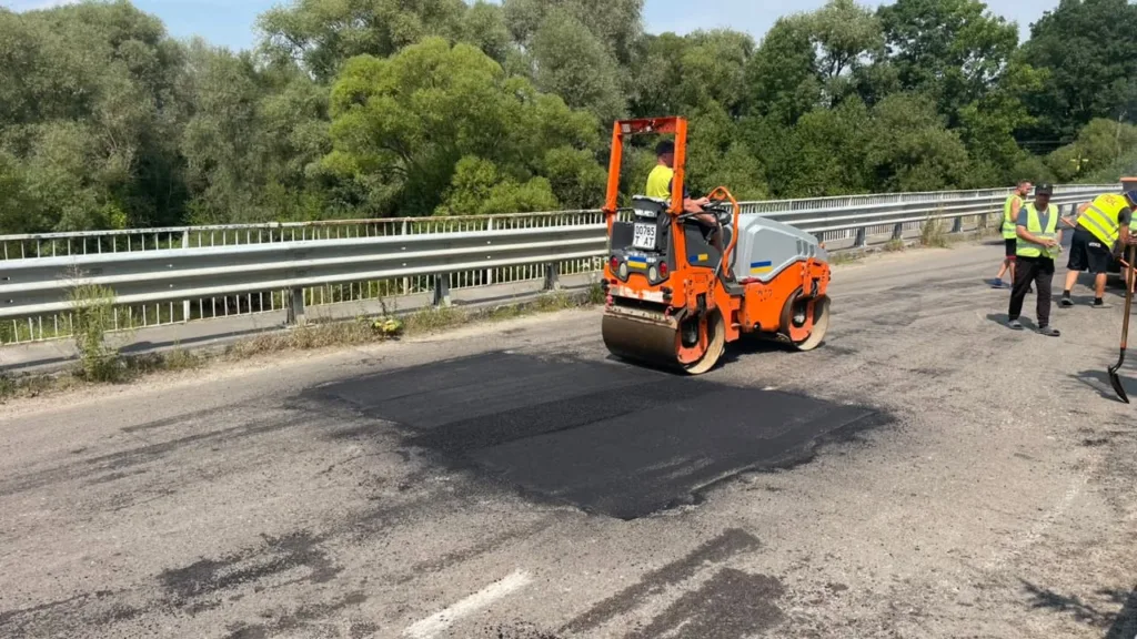 Дорожники асфальтують міст котком