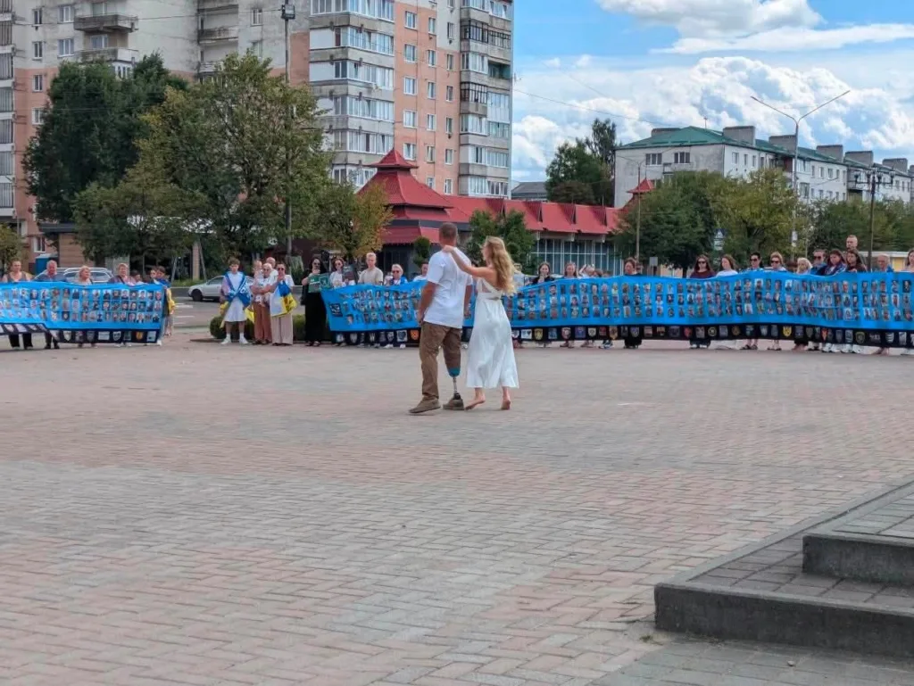 Люди тримають банер із портретами захисників України