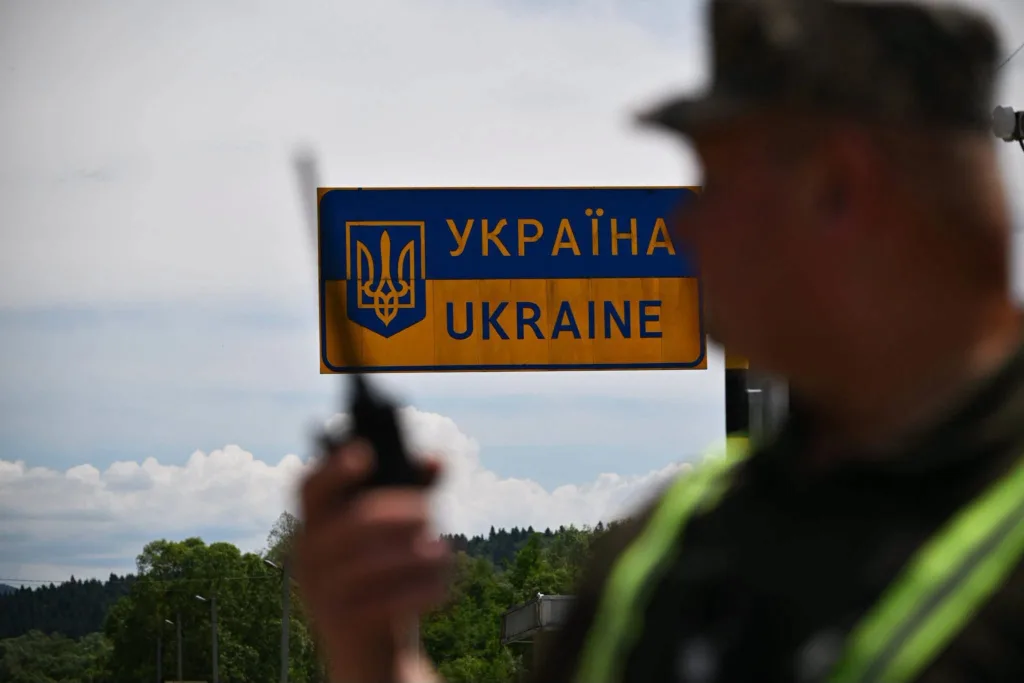 Прикордонник біля знака в’їзду в Україну