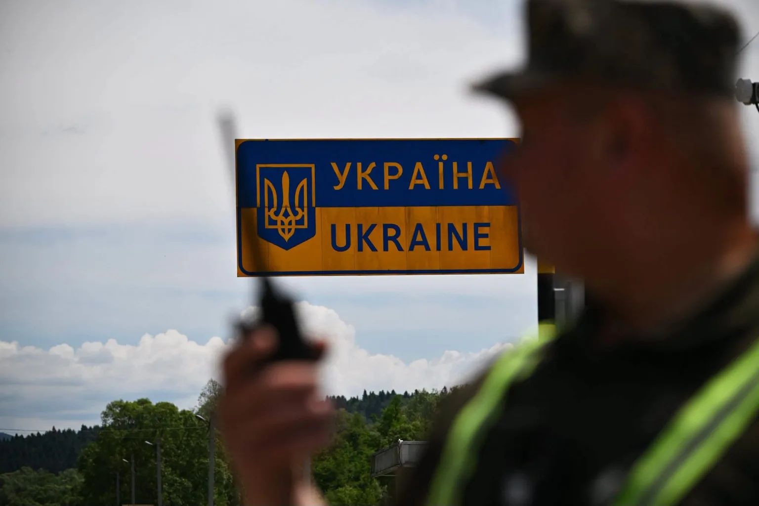 Прикордонник біля знака в’їзду в Україну