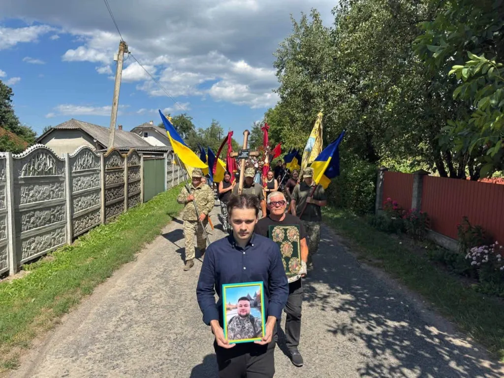 Жалобна процесія з портретом військового та українськими прапорами