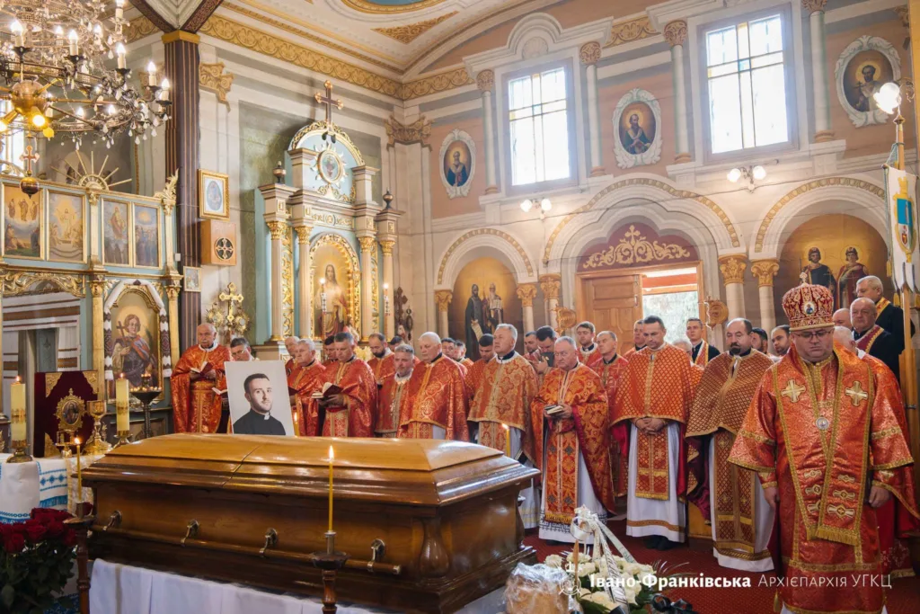 Священники моляться біля труни в храмі