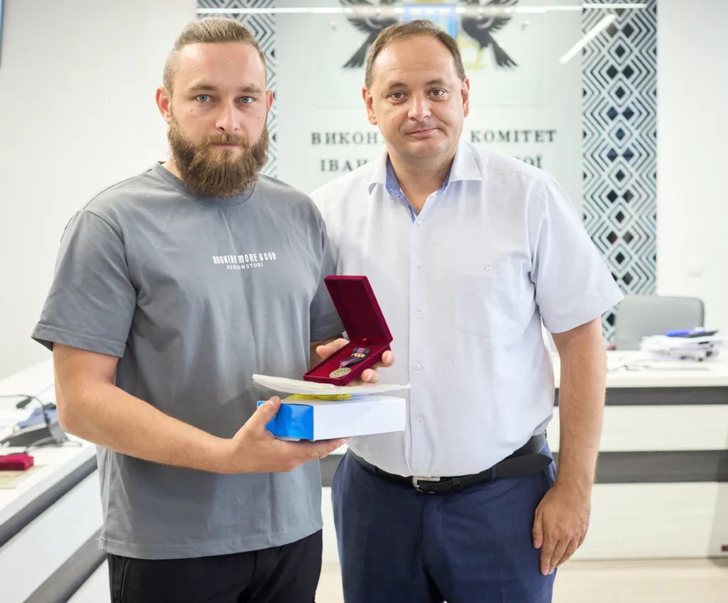 Двоє чоловіків демонструють медаль у футлярі