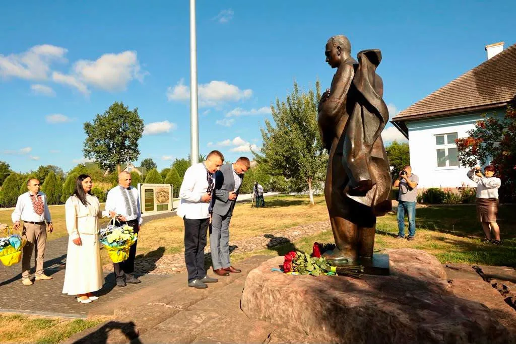 Люди вшановують пам’ять біля бронзового пам’ятника