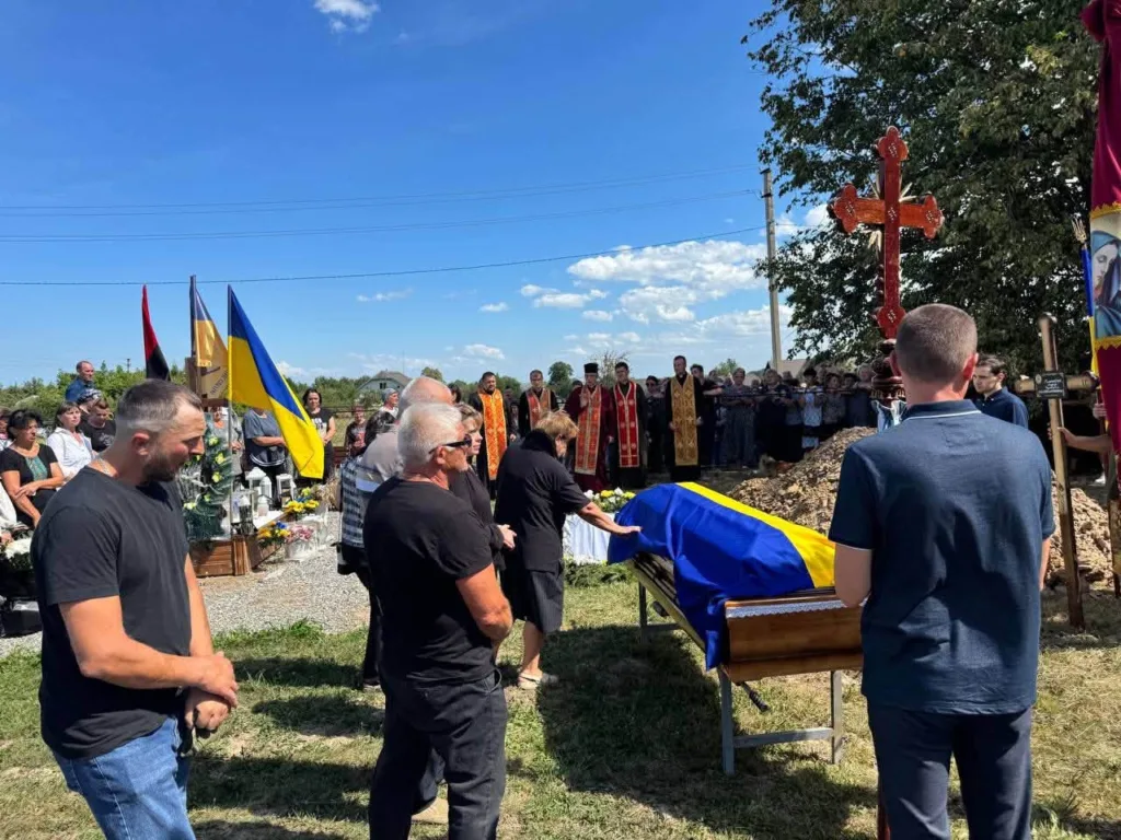 Похорон військового з труною, вкритою українським прапором