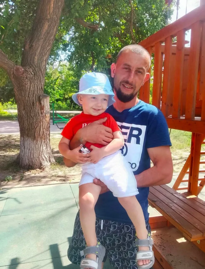 Чоловік тримає дитину на сонячному майданчику