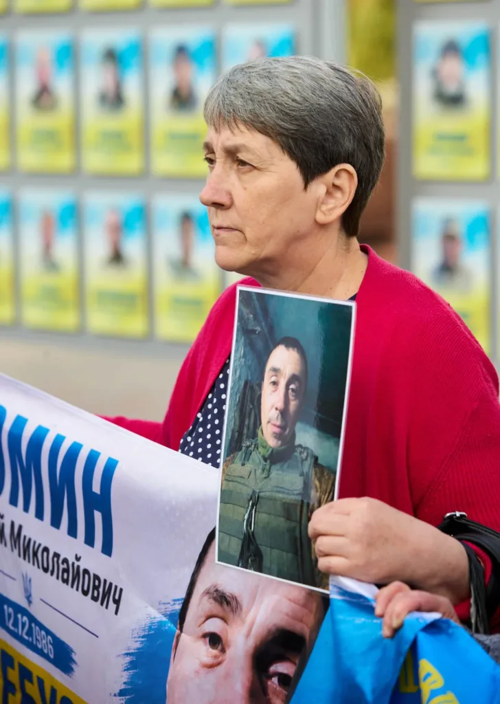Жінка тримає портрет військового на акції пам’яті