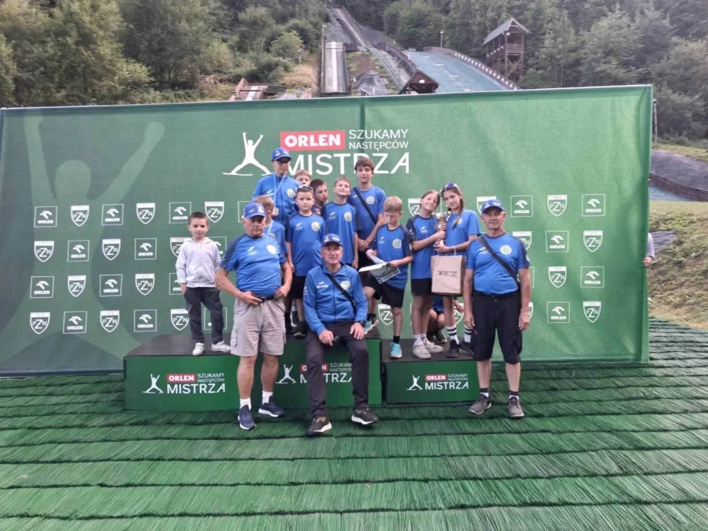 Юні спортсмени з тренерами на нагородженні зі стрибків