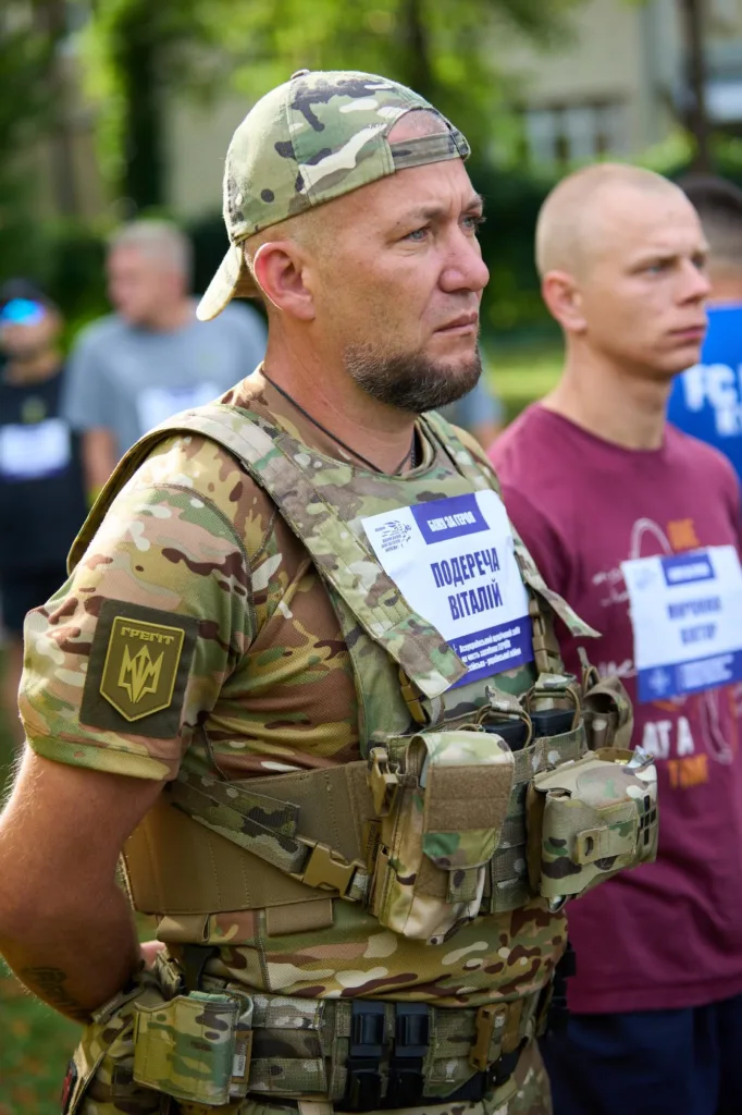 Військовий у камуфляжі стоїть серед учасників заходу