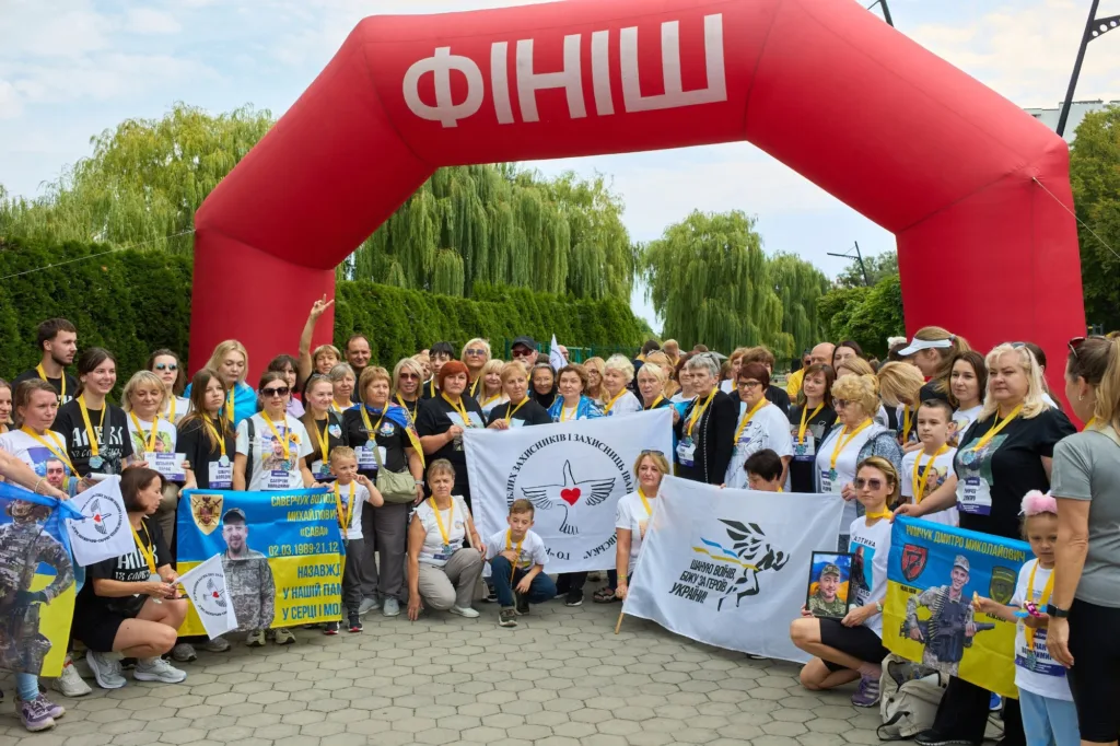 Родини військових під аркою фінішу з портретами героїв