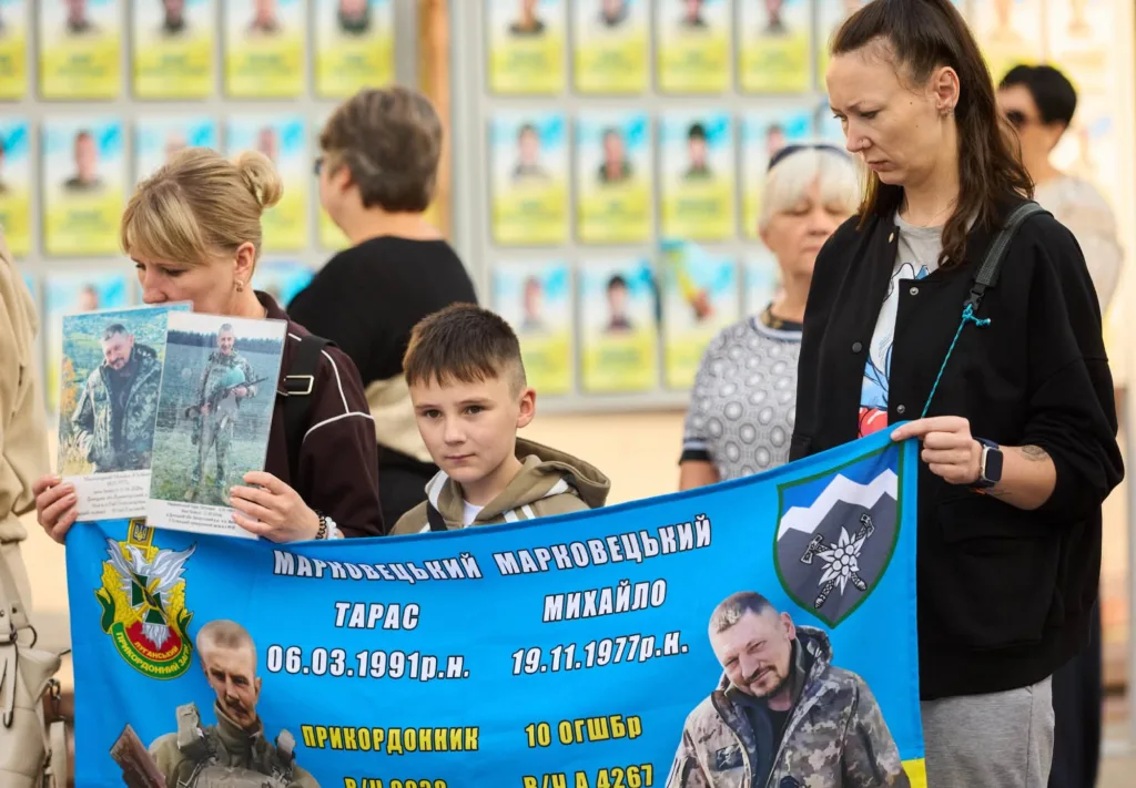 Родини тримають банер із портретами полеглих захисників
