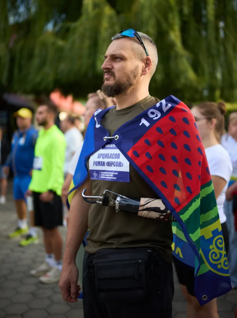 Ветеран із протезом руки стоїть серед учасників заходу