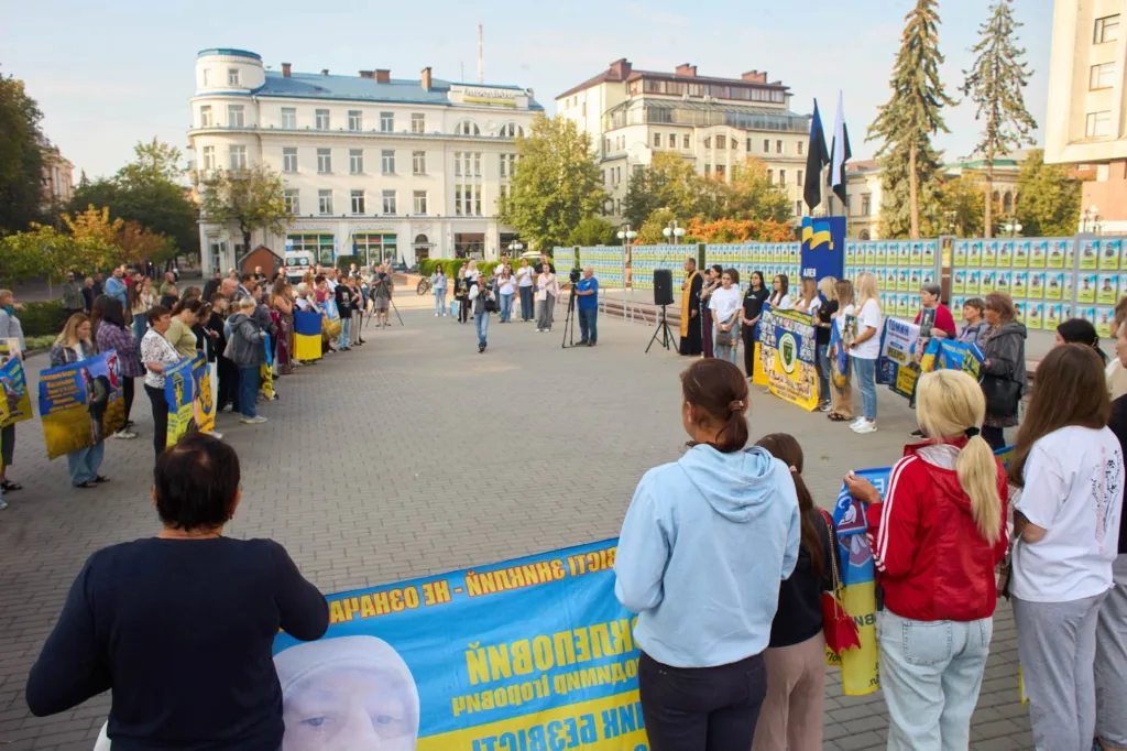 Люди з українськими прапорами на меморіальному заході