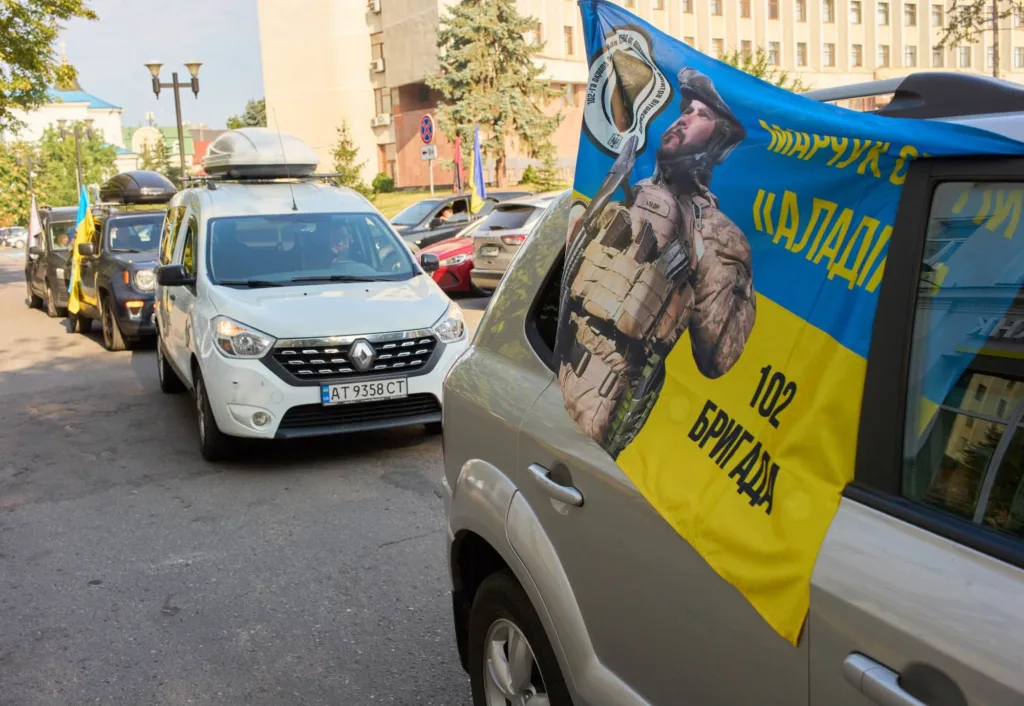 Автоколона з українськими прапорами та банером на підтримку захисників