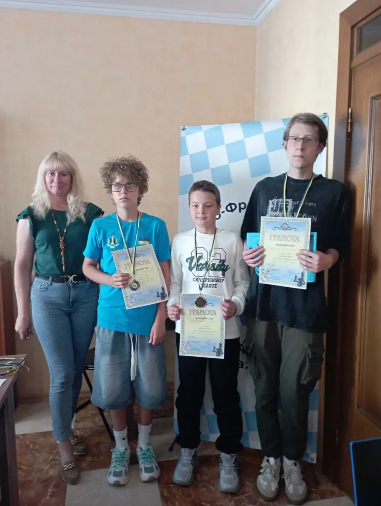 Юні шахісти з медалями й грамотами поруч із тренеркою