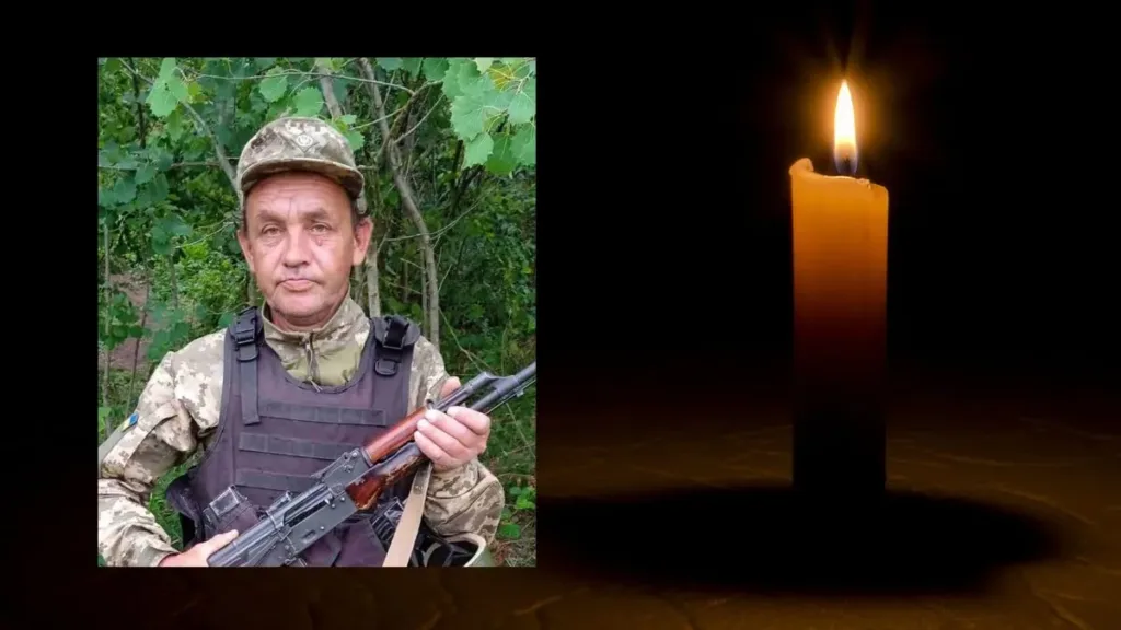 Портрет військового з автоматом поруч із запаленою свічкою